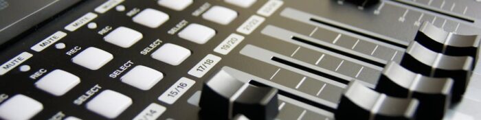 Detailed view of audio mixer sliders and buttons for sound engineering and music production.