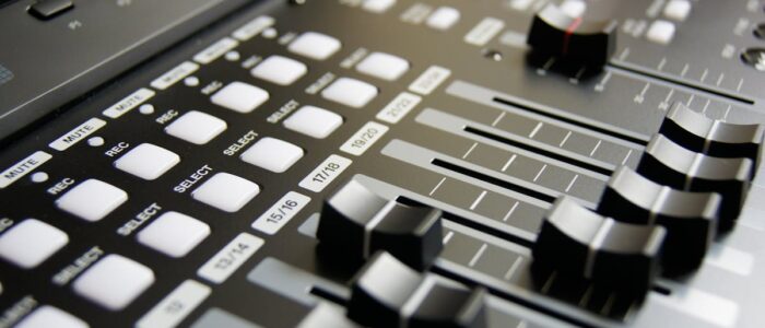 Detailed view of audio mixer sliders and buttons for sound engineering and music production.
