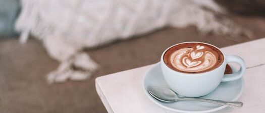 Latte with beautiful art in cozy café setting, perfect for morning relaxation.