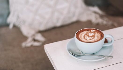 Latte with beautiful art in cozy café setting, perfect for morning relaxation.